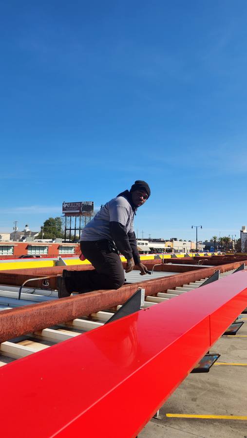 Tech on commercial rooftop during lighting install