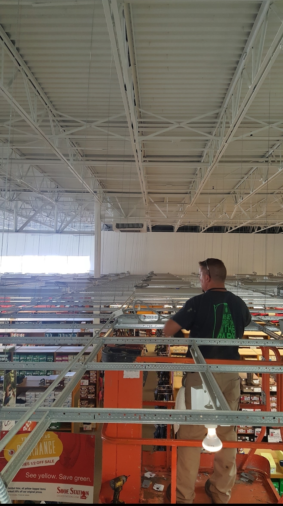 Tech on scissor lift high-bay retail