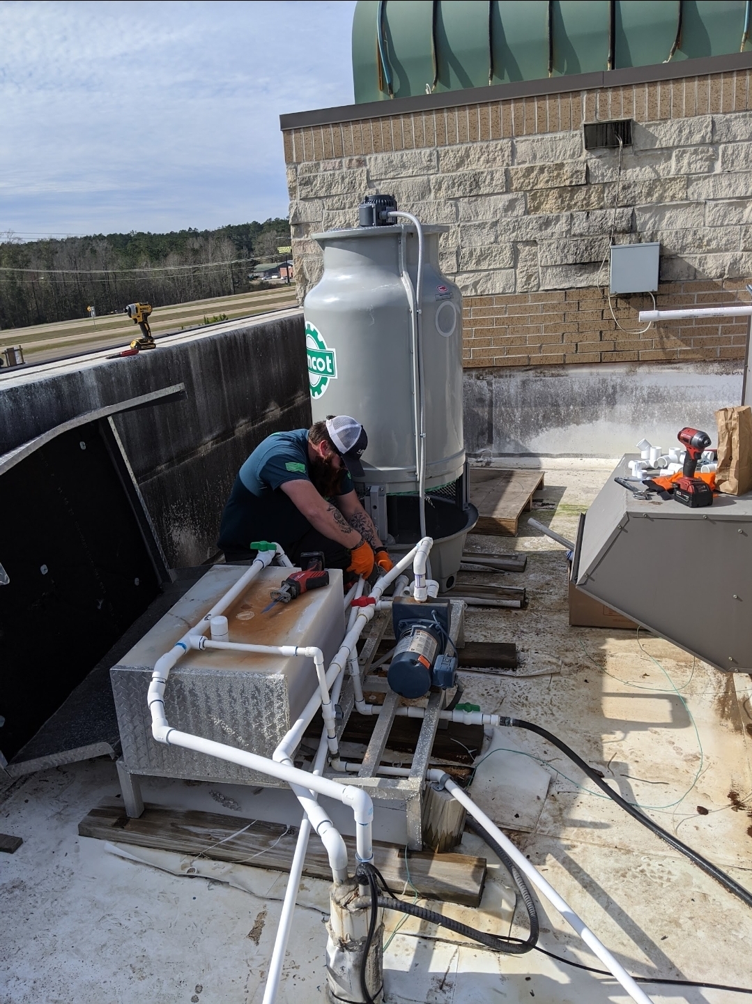 Tech on rooftop commercial cooling tower