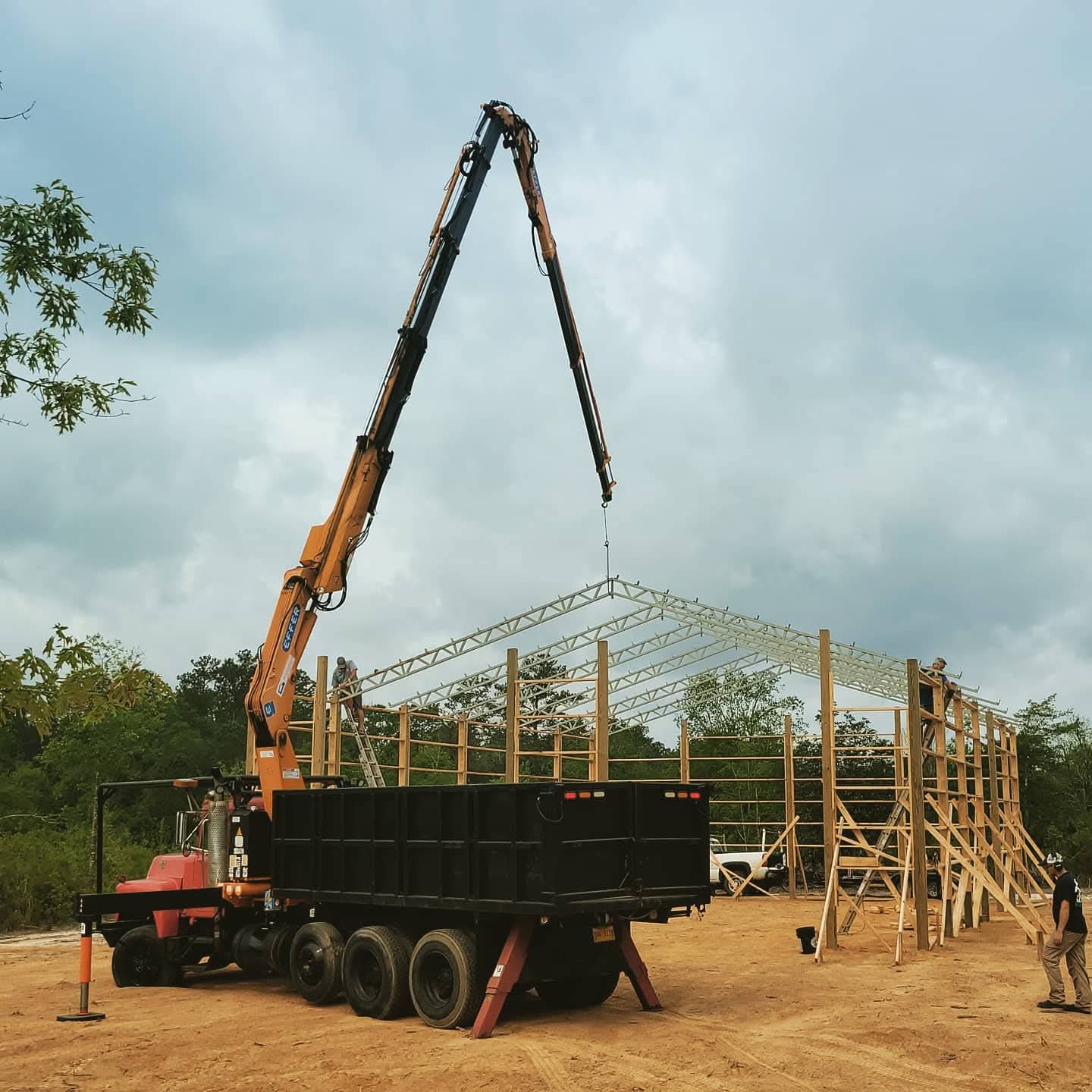 Crane lifting roof trusses for barn construction