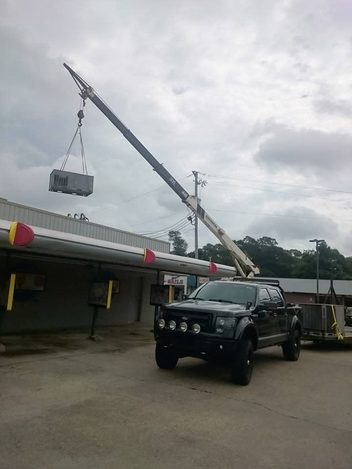 Crane lifting RTU onto strip mall roof